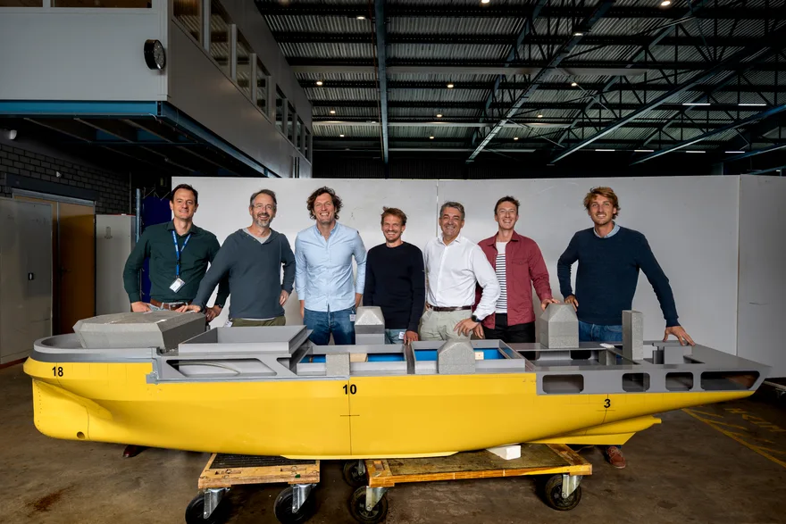 L’équipe réunie autour de la maquette d’un navire à propulsion vélique