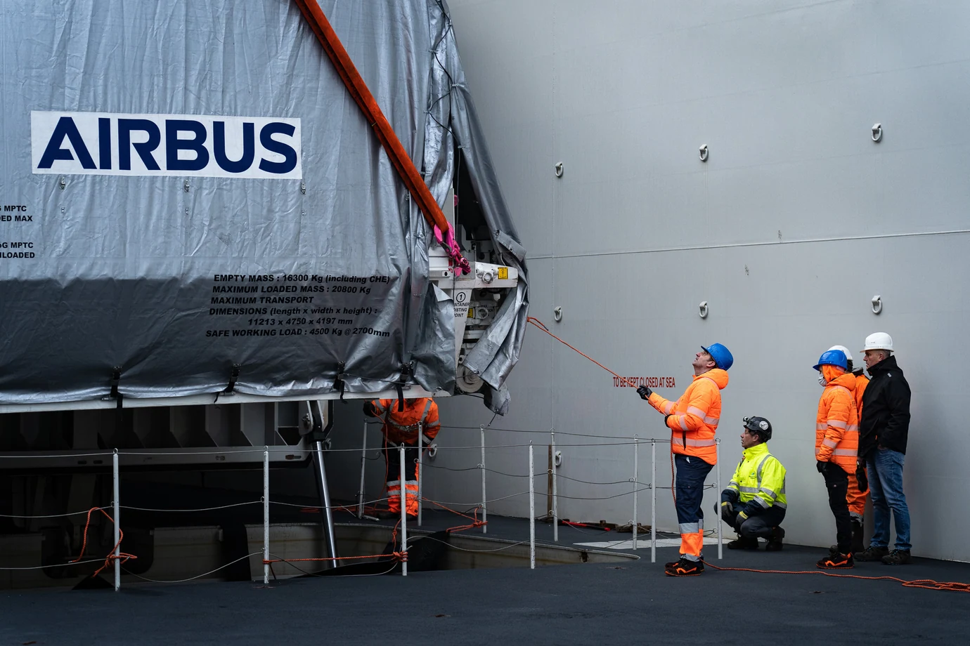 L’équipe casquée sur le quai, devant un conteneur Airbus chargé à bord du Canopée