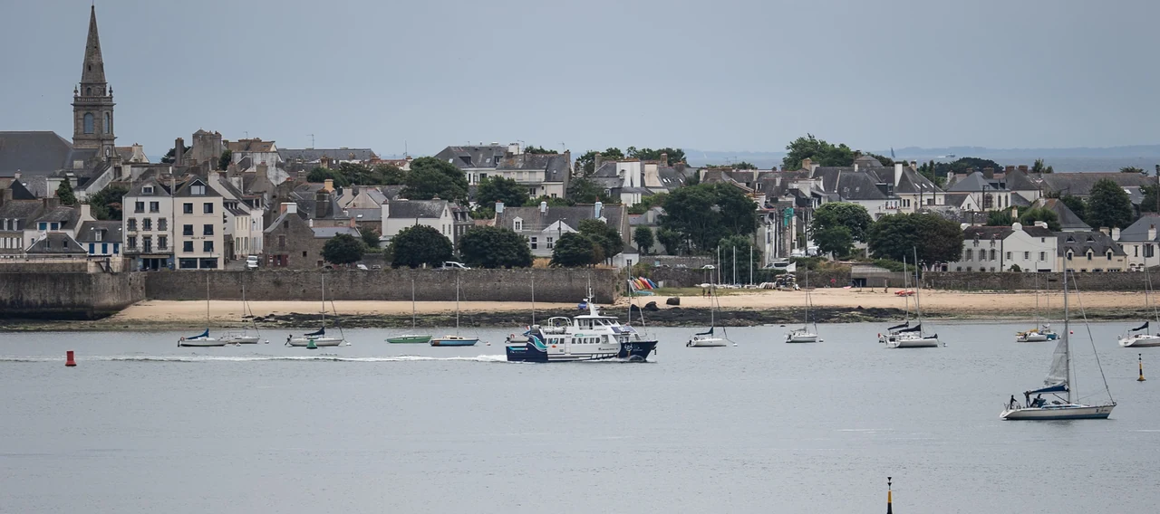 Un village de la rade de Lorient, son clocher et des voiliers au mouillage