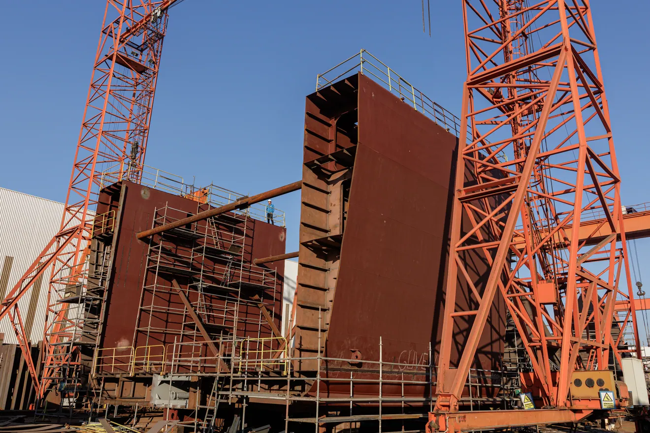 Blocs de coque du navire Windcoop en cours d’assemblage entre les grues du chantier