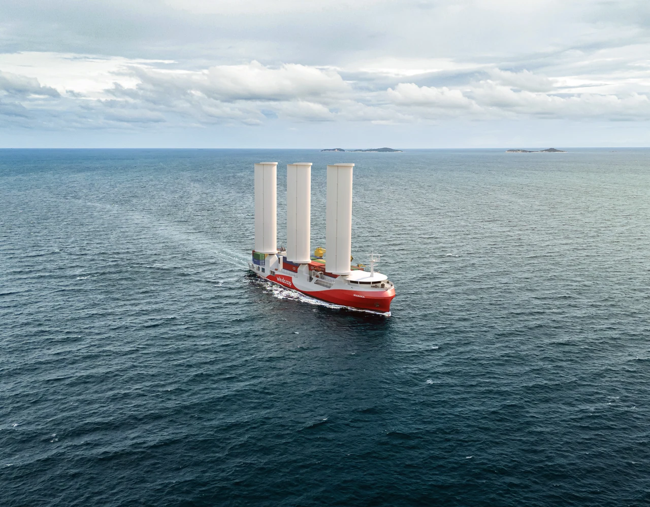 Le porte-conteneurs à voiles de Windcoop en mer, trois ailes déployées (image de synthèse)
